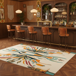 Bar area with wooden counter, stools, and a colorful rug on a wooden floor.
