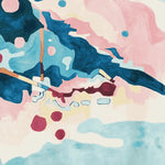 A vibrant hand-tufted wool area rug featuring an abstract design with bold splashes of blue, pink, and burgundy, ideal for contemporary living rooms.