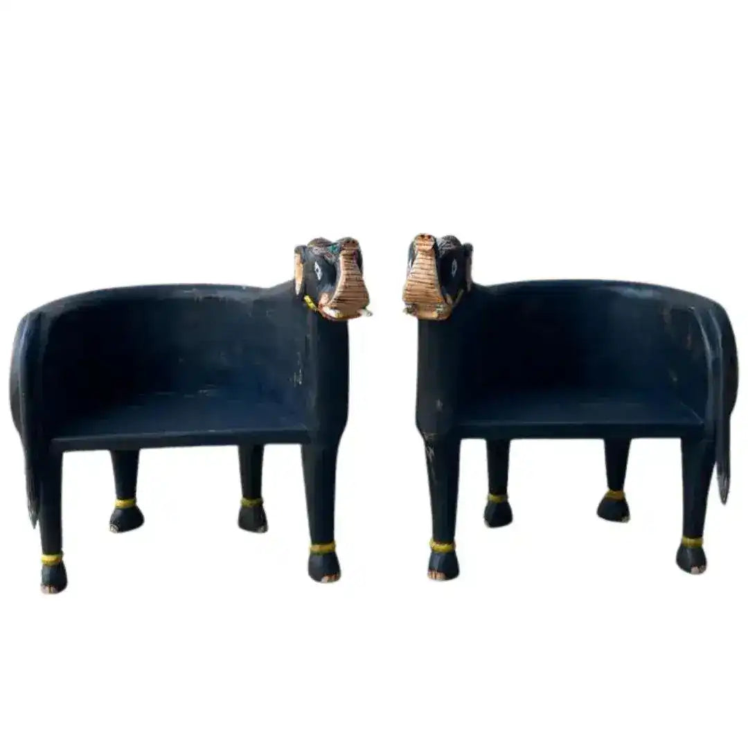 Pair of hand crafted wooden elephant Maharaja chairs in dark navy with gold anklets and carved elephant head backs, front view.