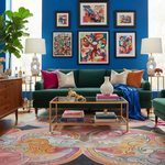 Colorful living room with a green sofa, abstract art, and patterned rug.