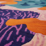 Close-up of a colorful abstract patterned rug with vibrant colors.