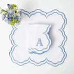 embroidered monogram placemat and napkin flat lay white scalloped blue embroidered border letter A monogram with blue flowers
