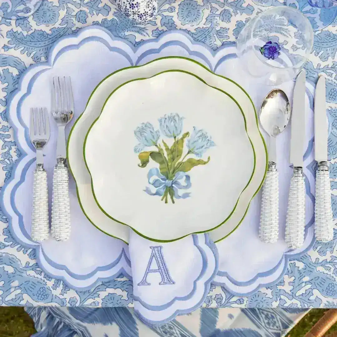 embroidered monogram placemat overhead view white scalloped blue border letter A napkin blue floral plate on blue tablecloth
