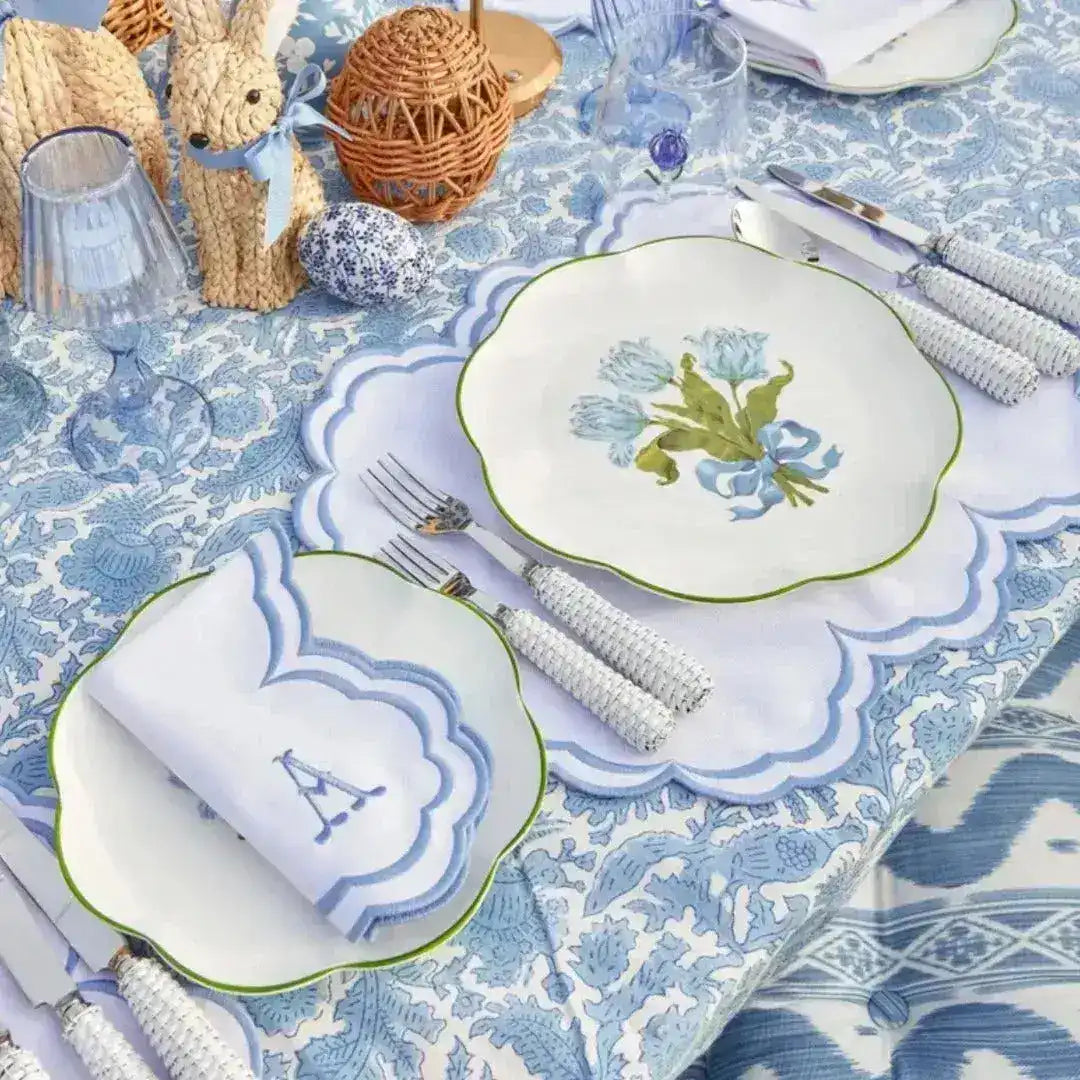 embroidered monogram placemat white scalloped blue border with A napkin monogram blue floral plate on blue botanical tablecloth