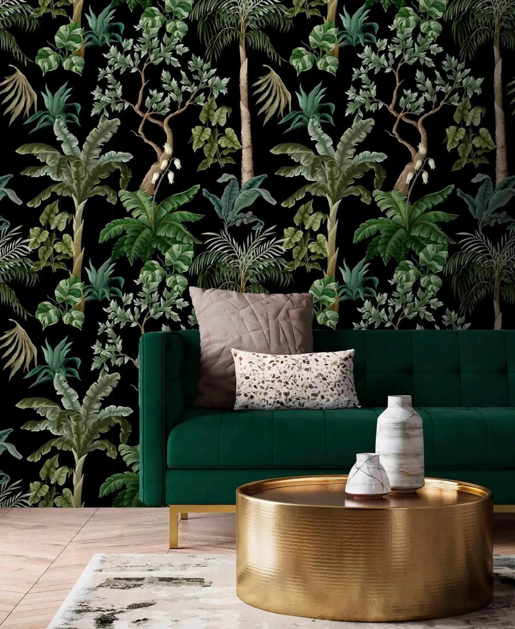 Emerald velvet sofa and gold drum table set against dark jungle foliage palm wallpaper