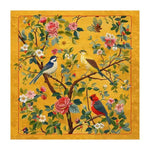 Vibrantly colored area rug, perfect for a large living room, featuring an intricate design of birds perched on blooming branches against a warm yellow background. This hand-tufted wool rug adds a touch of elegance and nature-inspired beauty to any living space.