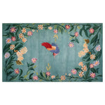 Vibrant area rug featuring a whimsical bird surrounded by colorful floral patterns on a soft blue-green background. The intricate design showcases a blend of nature-inspired elements in a knotted wool texture, perfect for adding a touch of enchantment to any room decor.