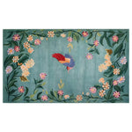 Vibrant area rug featuring a whimsical bird surrounded by colorful floral patterns on a soft blue-green background. The intricate design showcases a blend of nature-inspired elements in a knotted wool texture, perfect for adding a touch of enchantment to any room decor.