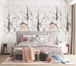 Enchanted Forest deer-and-owl wallpaper in a blush bedroom above an upholstered bed