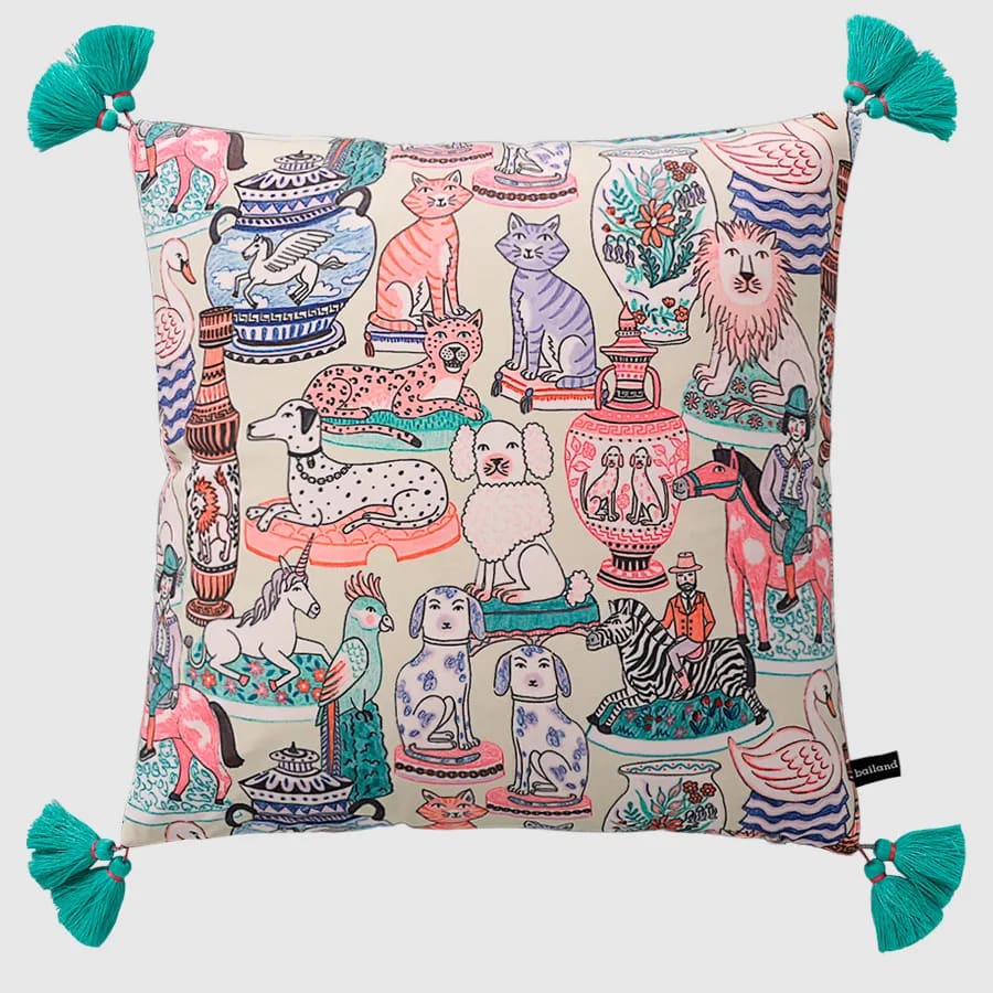 Luxurious throw pillow cover featuring a whimsical design with various animals, vases, and decorative elements, accented with turquoise tassels.