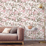 English Garden Wallpaper of pink blooms and sage leaves behind a blush velvet sofa, marble side table, and gold lamp.