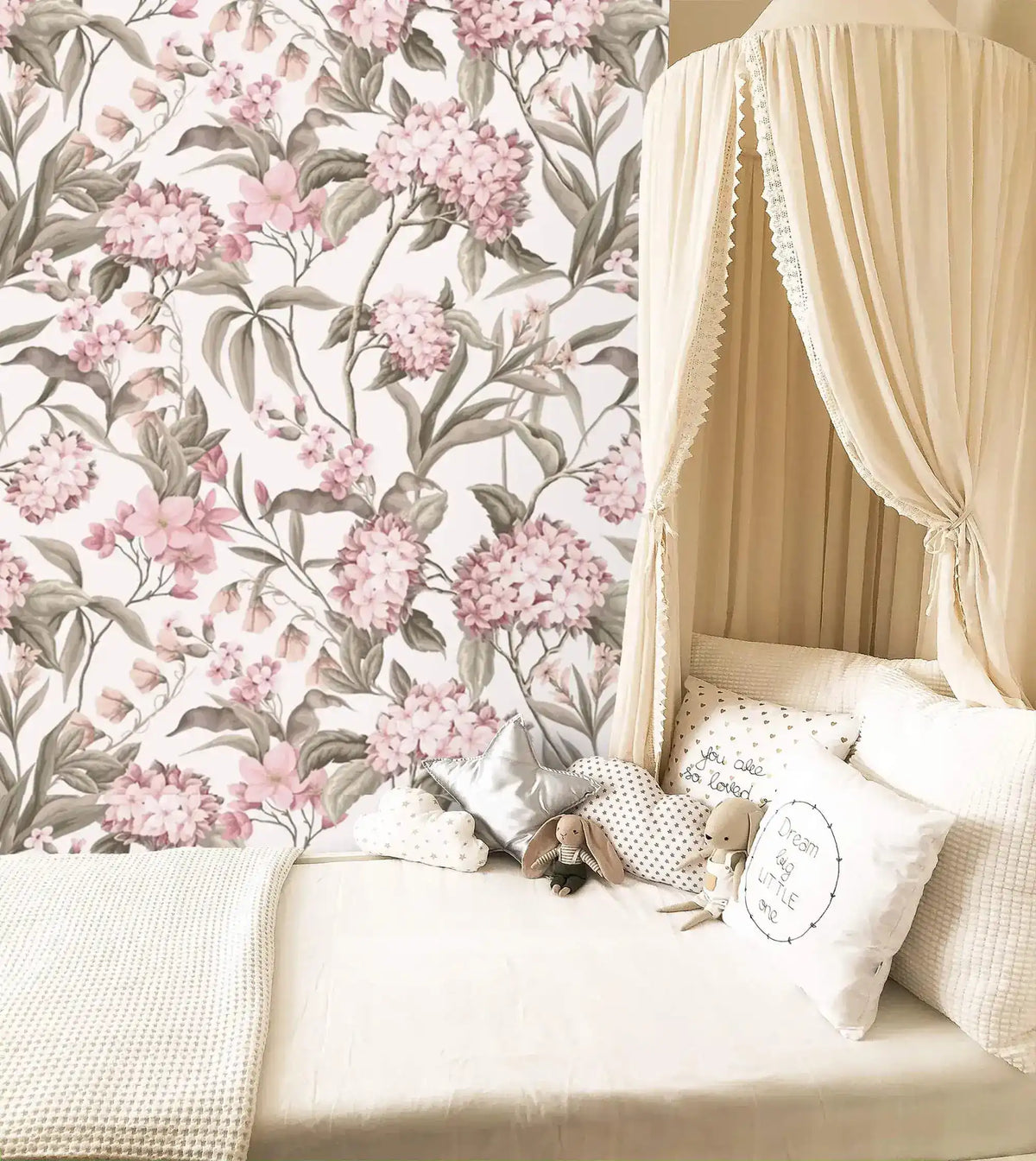 English Garden Wallpaper of pink hydrangeas and sage leaves behind a cream canopy bed with stuffed toys.