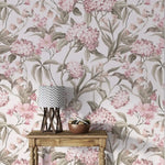 English Garden Wallpaper of soft pink hydrangeas and sage leaves on cream behind a wood console with a chevron lamp.