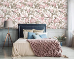 English Garden Wallpaper with large pink hydrangeas above a navy upholstered bed, pink knit throw, and tripod lamp.