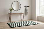 Striped rug on a wooden floor with a mirror, table, and coat rack in the background.