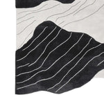 This contemporary area rug, perfect for adding a modern touch to your living room, features a hand-tufted design with striking black and white abstract stream vein patterns. Made from high-quality wool, this living room area rug combines style and comfort effortlessly.