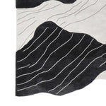 This contemporary area rug, perfect for adding a modern touch to your living room, features a hand-tufted design with striking black and white abstract stream vein patterns. Made from high-quality wool, this living room area rug combines style and comfort effortlessly.