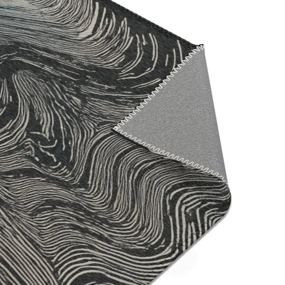 Close-up of folded corner on dark rug with cream-white flowing wave lines and grey canvas backing, Ethereal Archway Fluid Pathways Rug material detail