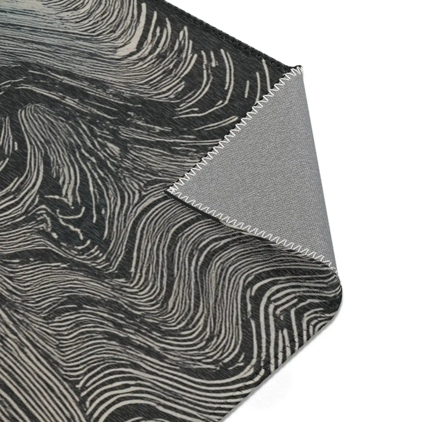 Close-up of folded corner on dark rug with cream-white flowing wave lines and grey canvas backing, Ethereal Archway Fluid Pathways Rug material detail