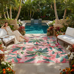 Woman sitting on a lounge chair by a pool with a pink floral rug