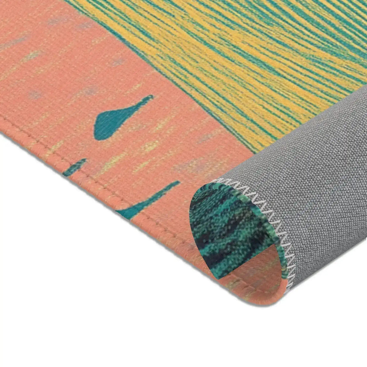 Corner roll of Ethereal Guardian Accent Rug showing peach border with teal bird silhouettes and gold striped field, gray backing with serged zigzag