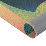 Corner of Ethereal Guardian Accent Rug curled showing peach and teal-green striped guardian print with gray non-slip backing and serged stitched edge
