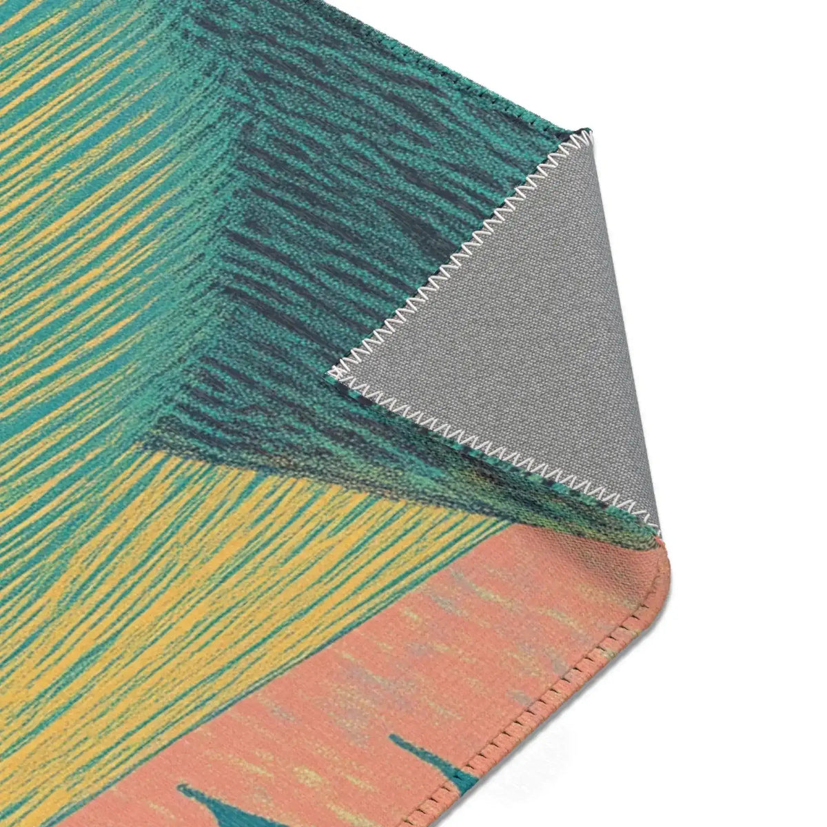 Folded corner of Ethereal Guardian Accent Rug showing teal and yellow striped print with peach border detail and gray backing with serged edge