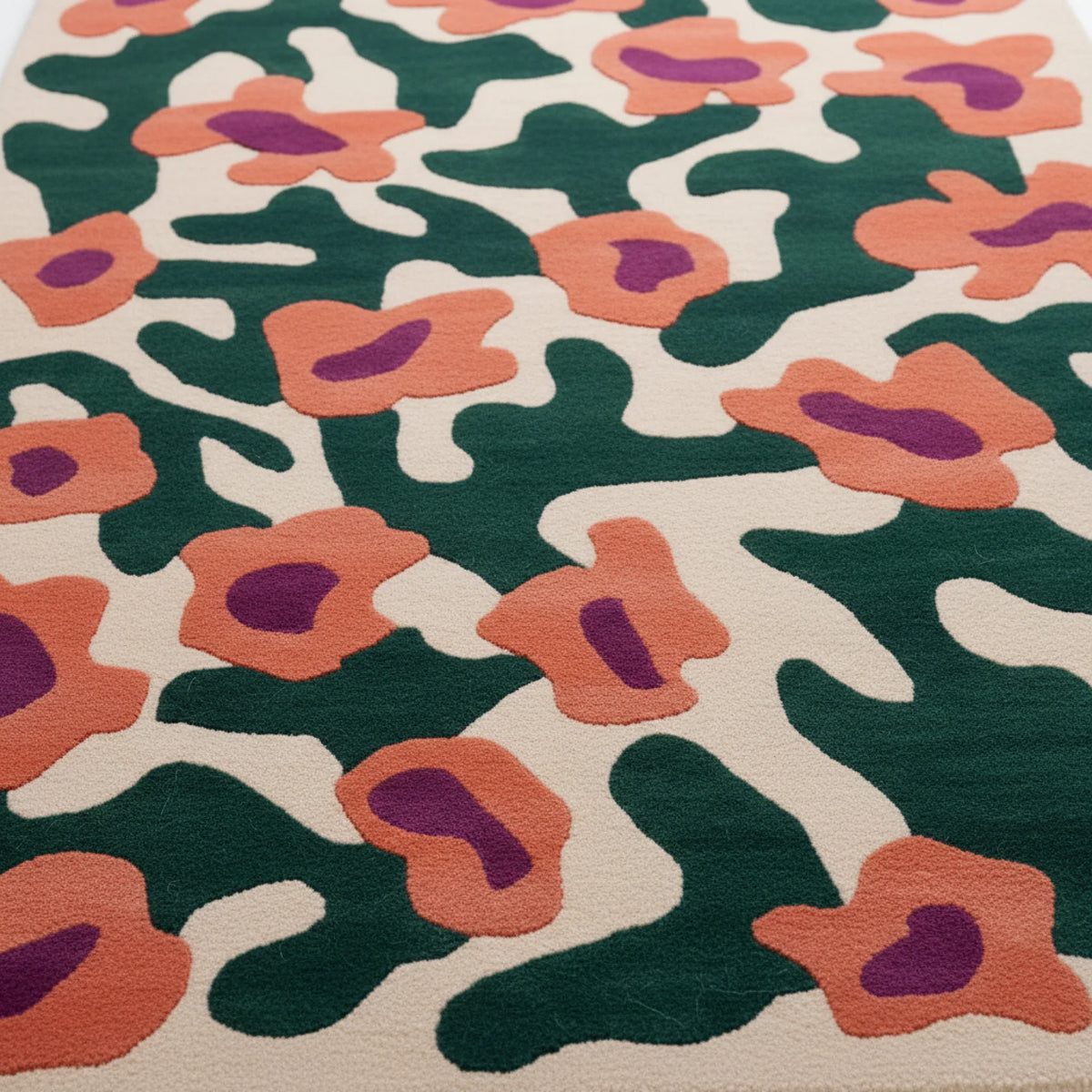 Close-up of a floral patterned rug with green, orange, and purple flowers.