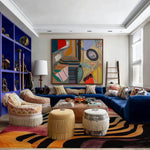 Evolving Forms viscose rug with bold black and orange swirling abstract pattern, styled with navy sectional
