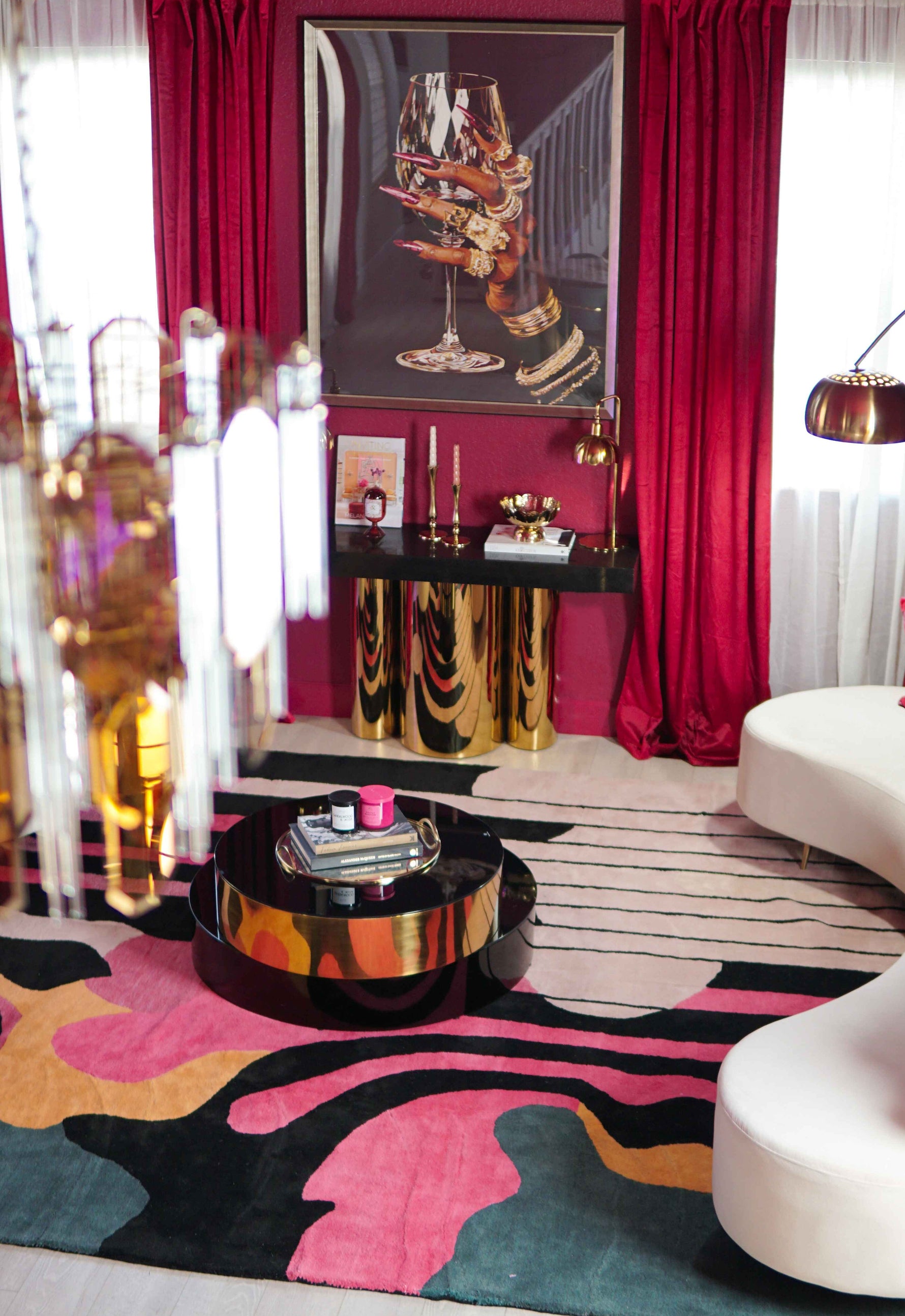 Evolving Shapes hand-tufted rug detail angle with pink black teal organic swirls and gold round coffee table