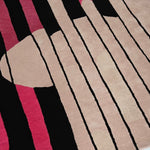close up shot pink, black, and beige patterned tufted wool rug