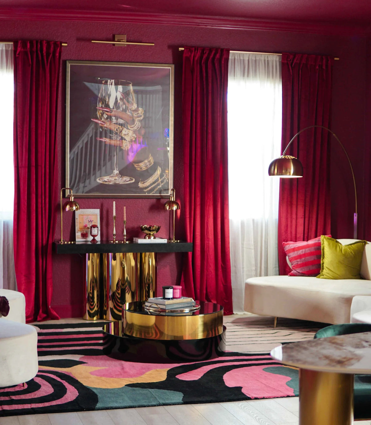 Modern living room with red curtains, colorful rug, and stylish furniture.