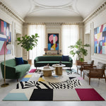 Modern living room with green sofas, colorful abstract designer rug, and abstract art.