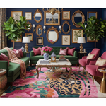 Colorful living room with green sofa, pink chairs, a tiger rug, and decorative elements.
