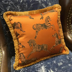 Faux silk throw pillow in vibrant orange with intricate horse pattern and golden fringes, perfect for adding a touch of elegance to your home decor.
