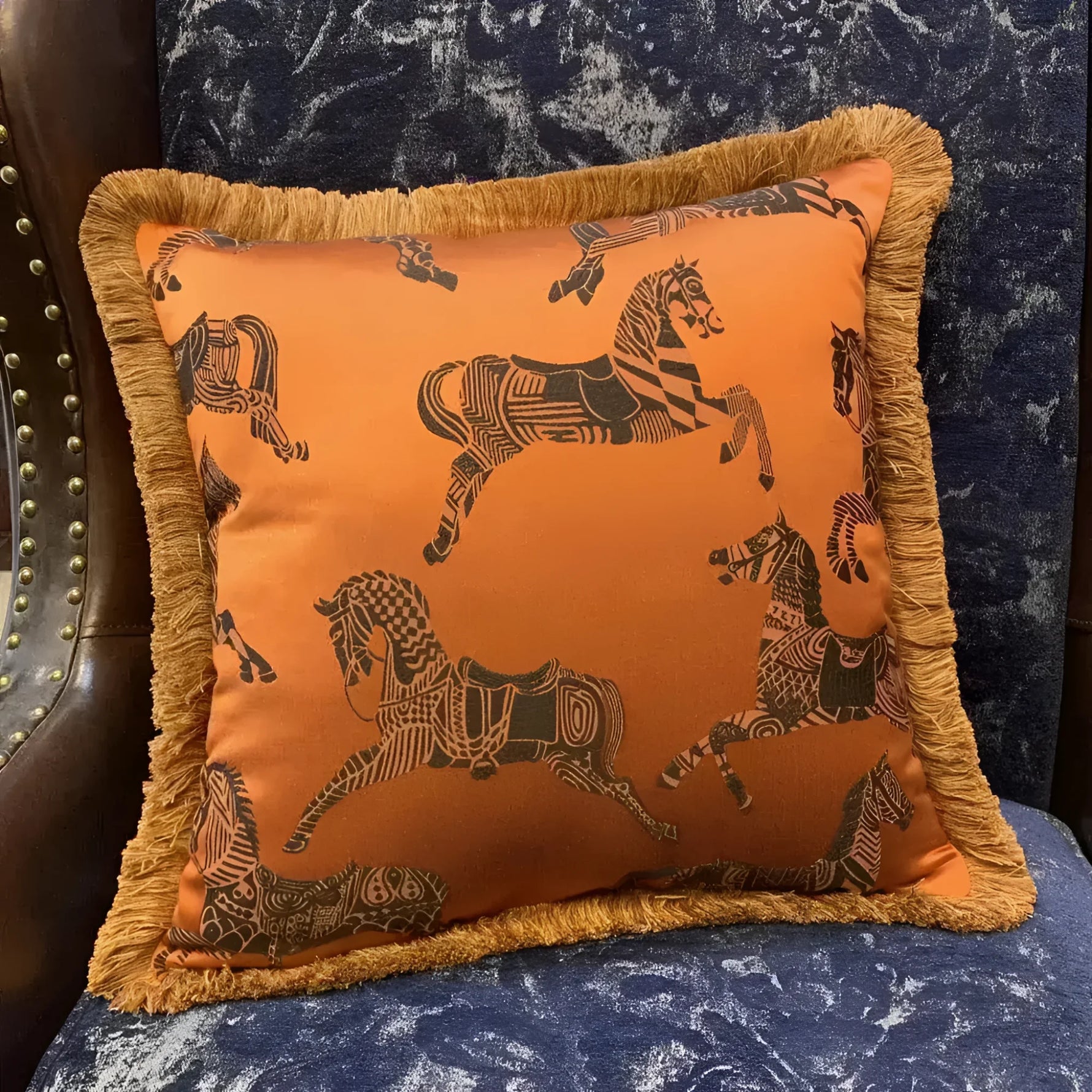 Faux silk throw pillow cover featuring an orange background with intricate black horse designs and golden fringes, perfect for adding a touch of elegance to your home decor.