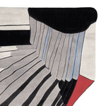 A contemporary hand-tufted area rug with bold geometric patterns featuring black, white, and red stripes. This wool rug is perfect for adding a modern touch to living room spaces, offering an artistic flair to any interior. Ideal for those seeking stylish living room area rugs.