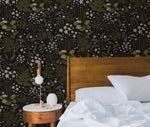 Fern blossoms monochrome wallpaper in a bedroom, dark black background with olive green fern fronds and white star flowers