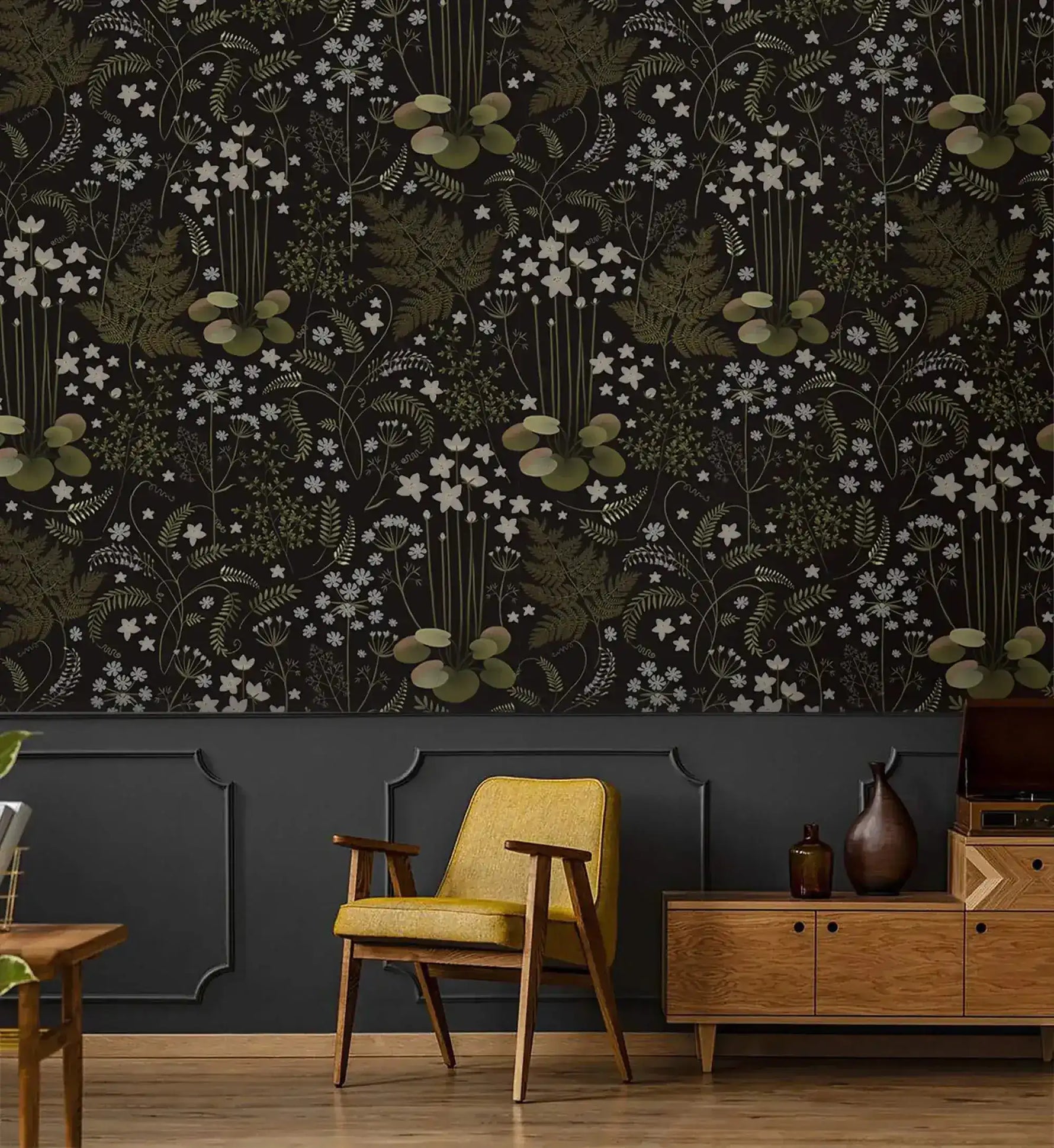 Fern blossoms monochrome wallpaper above dark wainscoting with a mustard yellow armchair and wood sideboard below