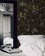 Fern blossoms monochrome wallpaper in moody bedroom with white pillows and a tall black mirror reflecting the room