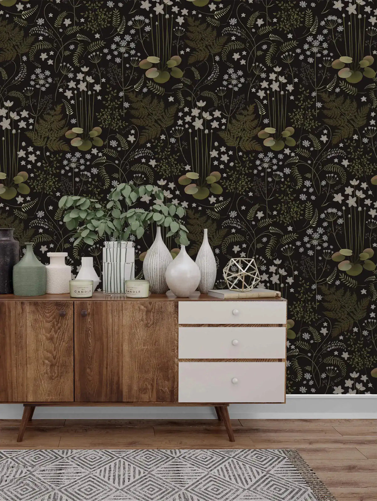 Fern blossoms monochrome wallpaper behind a wood sideboard styled with white vases and a potted plant