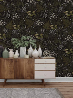 Fern blossoms monochrome wallpaper behind a wood sideboard styled with white vases and a potted plant