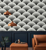 Fish scale art deco wallpaper in black and white scalloped fans above navy paneling with copper pendants