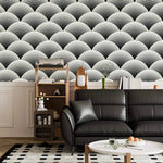 Fish scale art deco wallpaper in living room, black and white scalloped fans above a black leather sofa