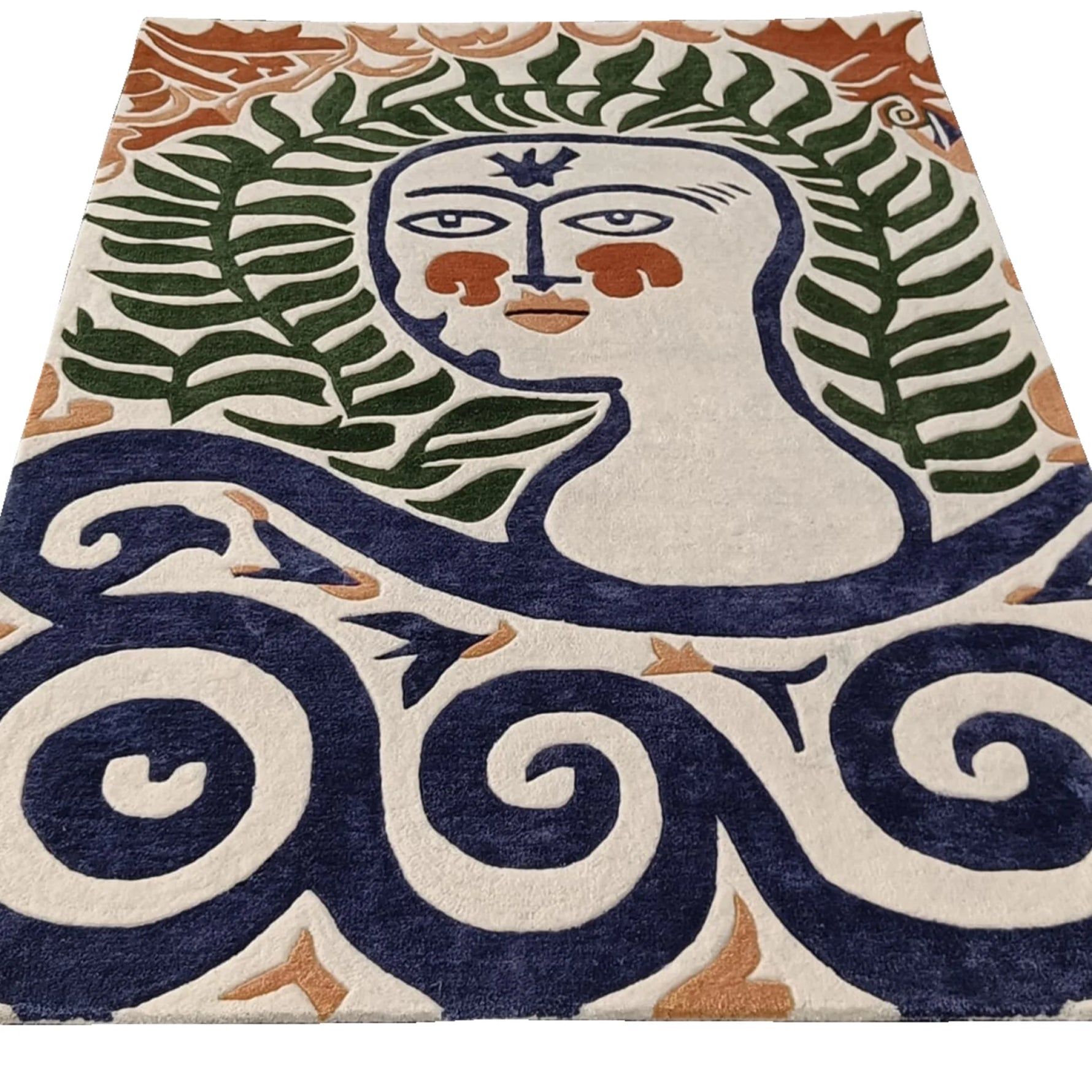 Flat view of a hand-tufted rug depicting a serene face with fern-frond hair above navy swirls on cream wool