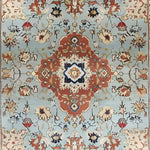 This image showcases the Floral Cascade Blue Hand Knotted Area Rug, featuring a stunning floral pattern with intricate details. The rug displays a central medallion design in warm tones against a blue background, embodying a vintage Persian rug style. Perfect for large living rooms, this square area rug is crafted from wool, providing both elegance and durability.