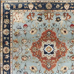 Close-up view of a Floral Cascade Blue Hand Knotted Area Rug showcasing intricate patterns and vibrant colors. This square area rug is ideal for large living rooms, offering a vintage Persian rug style that enhances any space. Made from wool, this large area rug brings elegance and warmth to your living room.