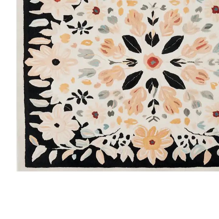 Close-up of the Floral Crown Hand Tufted Wool Rug showcasing its intricate floral pattern. This elegant area rug features a harmonious blend of soft colors like peach, cream, and black, making it a perfect addition to your living room. Ideal for those seeking an 8x10 living room rug with a stylish floral design, this wool rug brings warmth and charm to any space.