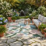 Outdoor patio with floral rug, wooden furniture, and potted plants in a garden setting.