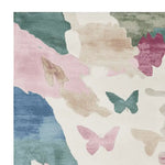 A contemporary hand-tufted area rug featuring a floral drift pattern with soft hues of pink, blue, green, and beige. This wool rug is perfect for adding a touch of elegance to living room spaces, offering both style and comfort.